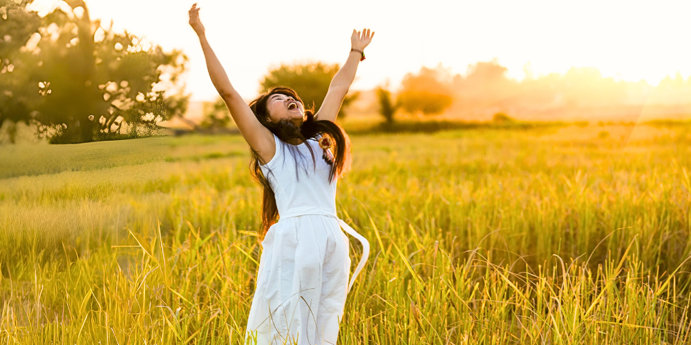 Woman in Field Reaching Toward Sky
