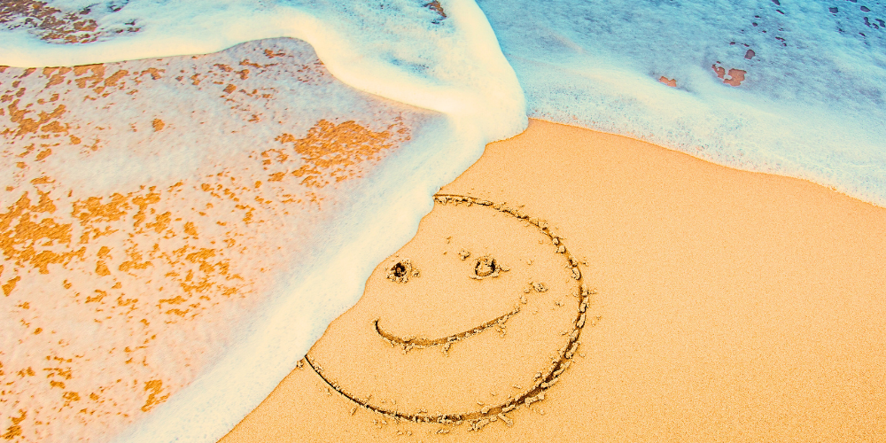 Smiley Face Traced in Sand at Beach